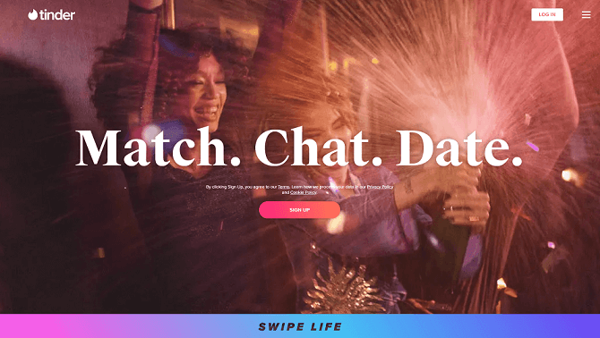 Tinder login page, with two single ladies celebrating and popping champagne.
