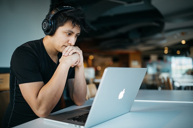 Asian working on his laptop