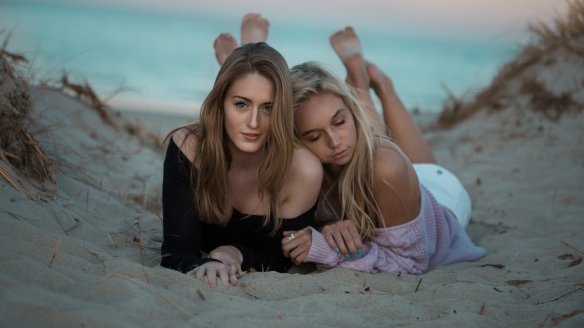 Bisexual girls cuddling at the beach