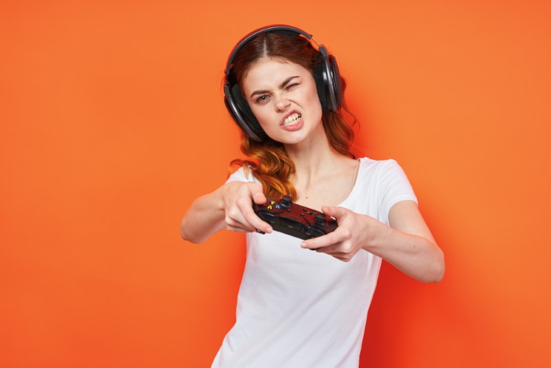 Cute nerd chick focused on her console game