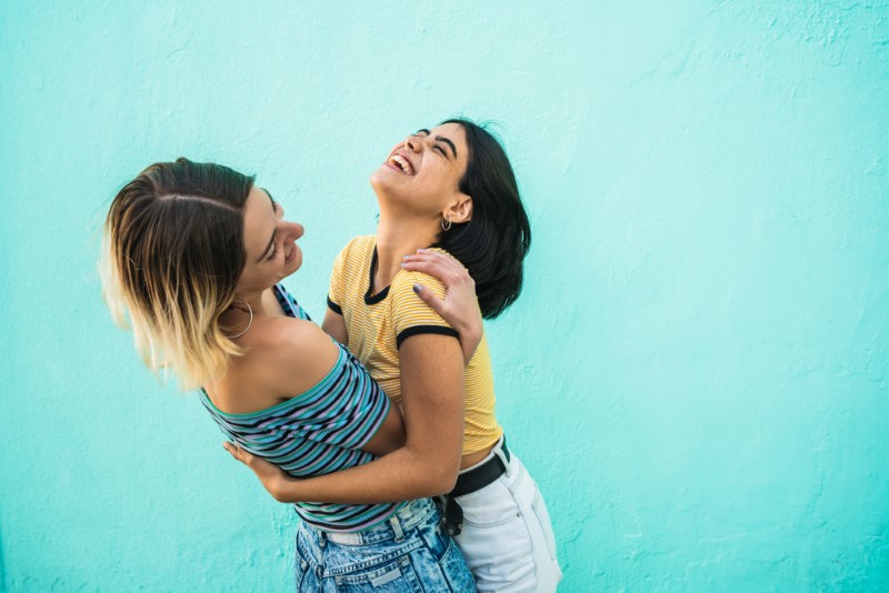 Lesbian girl lifts her girlfriend up in the air