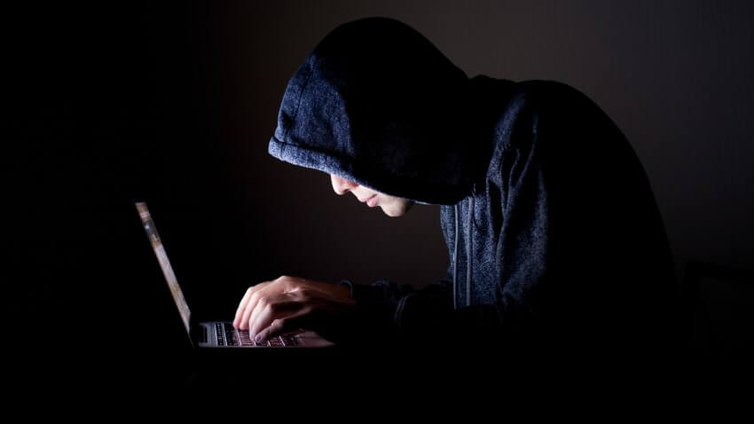 Hacker on his laptop scams people on dating sites