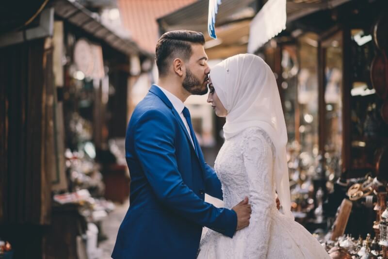 Newly-wed muslim husband kisses bride on forehead