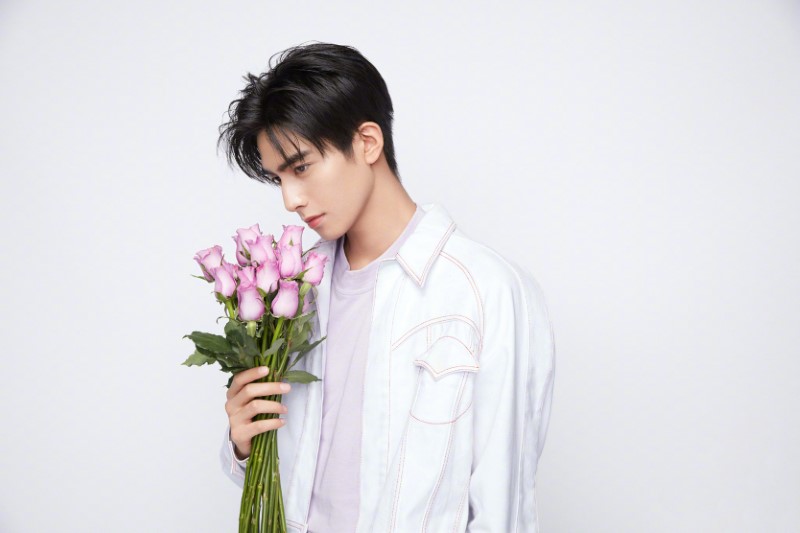 Chinese actor song weilong holds purple rose bouquet posing