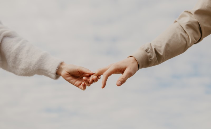 Two people taking each other's hand