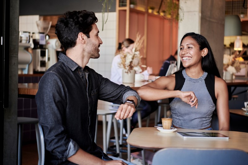 Two people on a date bumping elbows