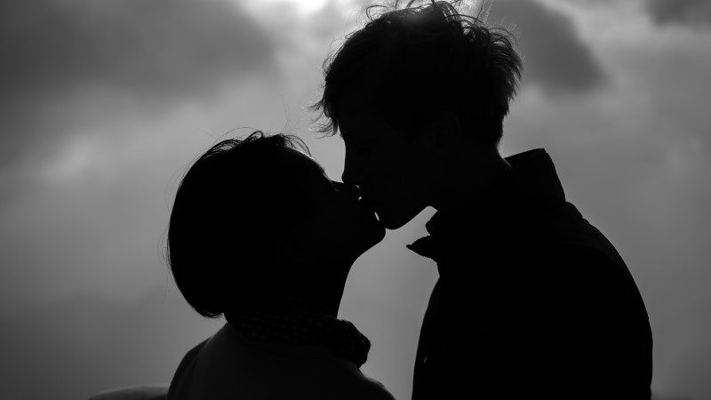 Silhouettes of two people kissing