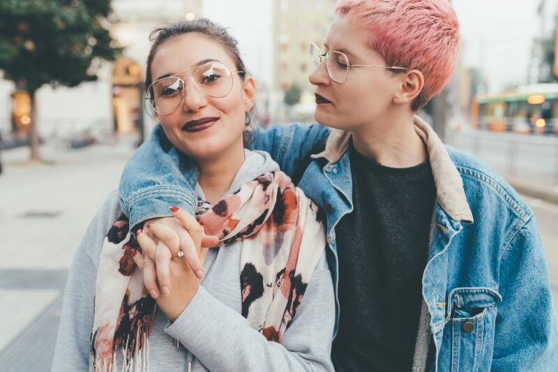 Two women outdoors holding hands