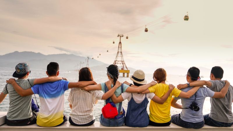 Friends sitting together hugging and watching the scenery