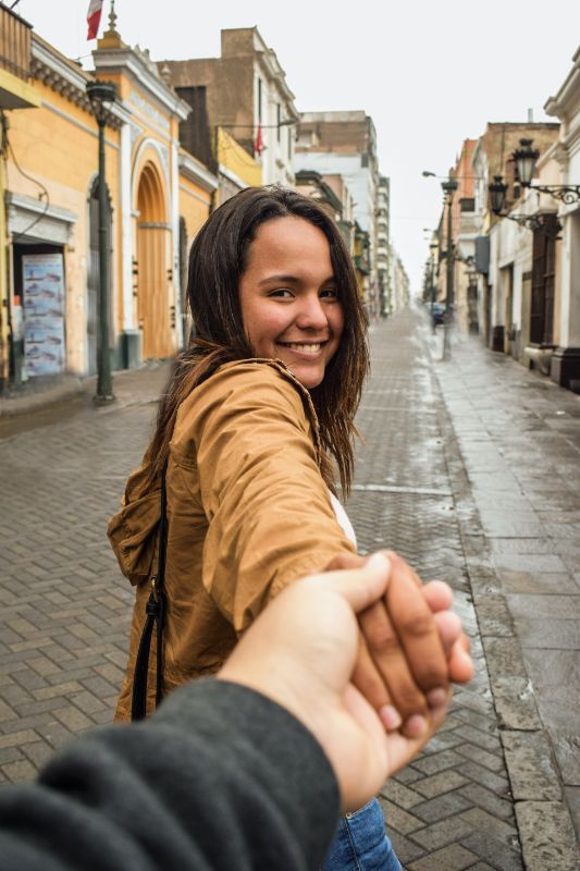 Girl holding hands with person behind the camera