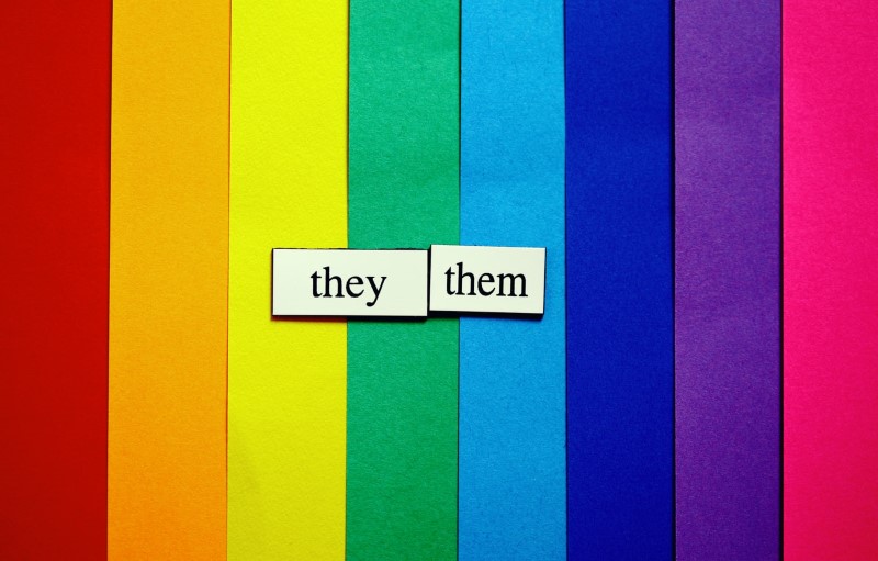 They/them labels in font of rainbow colors